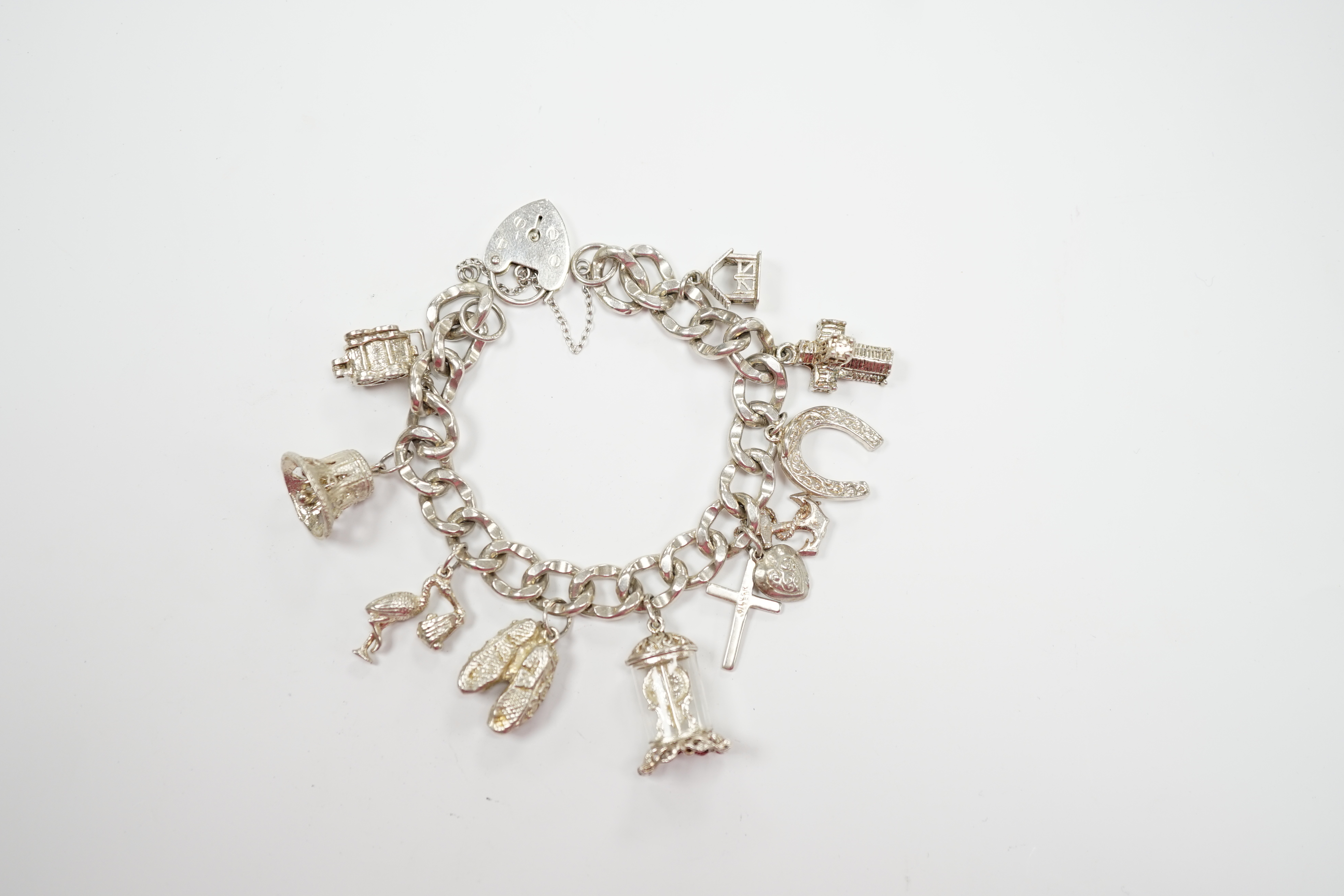 A modern silver charm bracelet, hung with nine assorted charms.